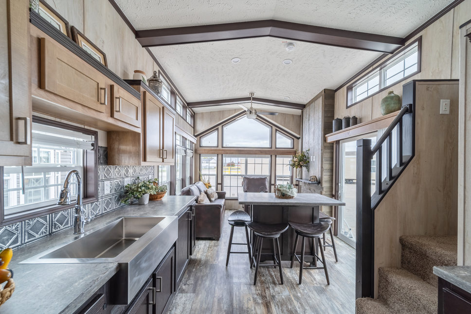 Ceiling beams, loft, farm sink and more in the 100177 Country Manor park model by Fairmont. 