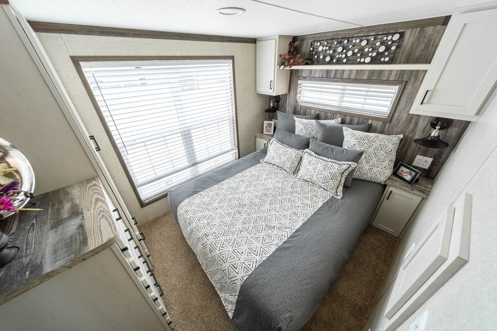 The amazing bedroom of the 100171 Country Manor park model has every storage and lighting feature you could want.
