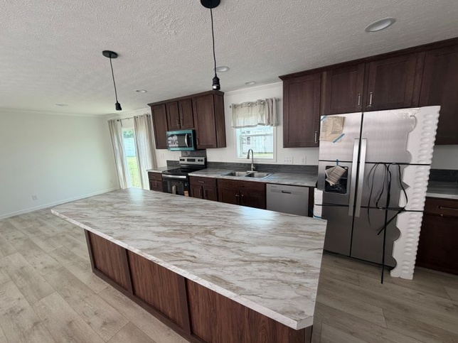 Kitchen with island and stainless steel appliances 