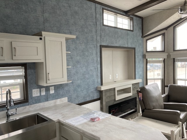 Entertainment center with electric fireplace and lots of windows for light in the 100152 Country Manor from Fairmont Homes.