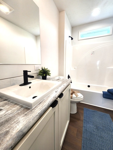 A painted wood vanity, contemporary matte black finishes, and abundant natural light create a guest bath that's as beautiful as it is functional.

#ABetterWayToBuild