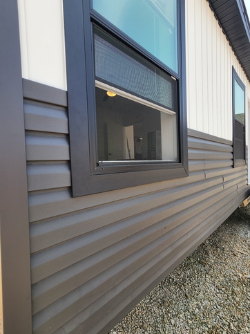 A stunning blend of modern farmhouse style. Black windows and trim, carbon horizontal siding below, and crisp white vertical siding above come together for a look that's both bold and timeless. #ABetterWayToBuild